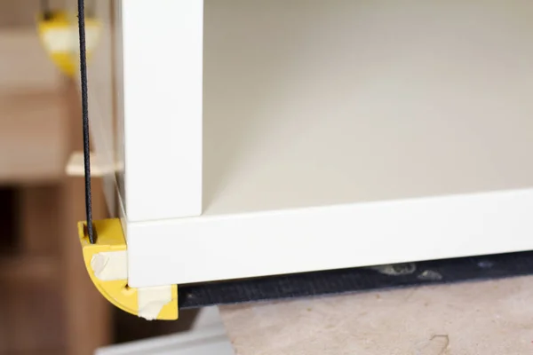 Gluing and fixing wooden furniture with a few clamps on a blurred background of a carpentry workshop, selective focus — Stock Photo, Image