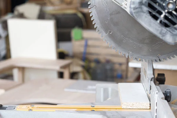 Close-up stationary circular saw on a carpentry table on a blurred background of a carpentry workshop, selective focus — Stock Photo, Image