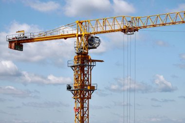 Mavi gökyüzü arka planı üzerinde sarı bir inşaat vincinin yakın çekim, seçici odak