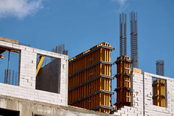 Construcción de un edificio de gran altura, la formación de soportes de cemento en formas prefabricadas contra un cielo azul, enfoque selectivo — Foto de Stock