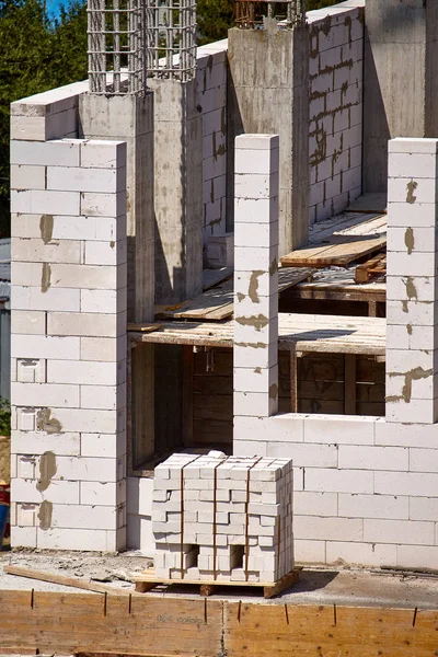 El proceso de construcción de la siguiente planta de un edificio de gran altura, soportes de cemento y paredes de bloques de cemento, enfoque selectivo — Foto de Stock