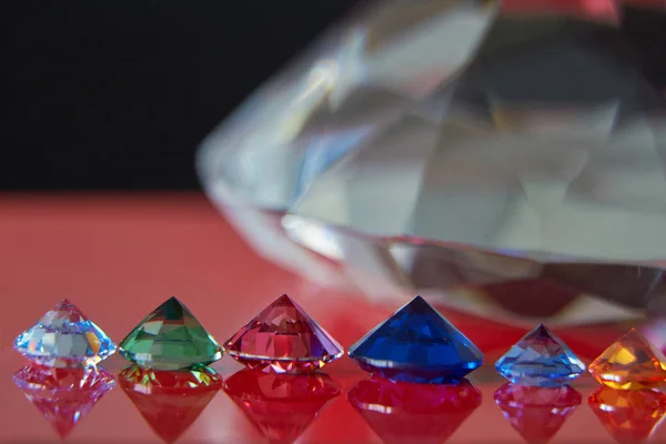 Huge diamond and several chic crystals on a red and black surface, shimmer and sparkle — Stock Photo, Image