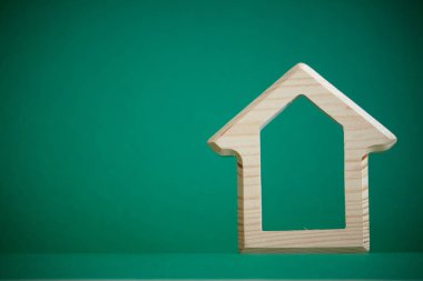 Yeşil arka planda evin ahşap rakam, satın alma veya bina kiralama kavramı, çevre dostu çevre, seçici odak