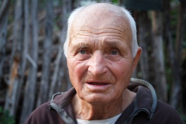 Wattle arka plan karşı çok yaşlı bir adamın yakın çekim portresi, seçici odak