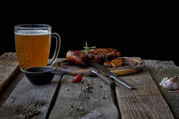 Bodegón con un gran filete frito, un vaso de cerveza, mostaza y cubiertos sobre una vieja mesa de madera, el concepto de Oktoberfest y el Día de San Patricio —  Fotos de Stock