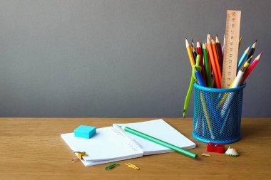 Okul konseptine, okul malzemelerine ve ahşap bir yüzeye açık bir deftere, seçici odak