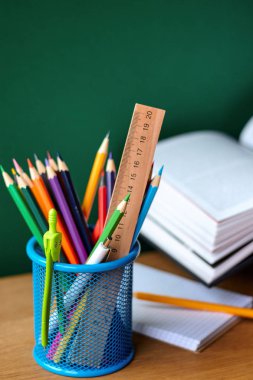 Geri okul konsepti, okul malzemeleri ile mavi cam, açık ders kitabı ve temiz yeşil tebeşir tahtası bir arka plan üzerinde dizüstü bilgisayar, seçici odak, kopya alanı