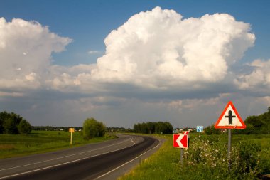 Tarlanın yanındaki köye giden yol ve birçok yol işaret ve işaretleri, seçici odak