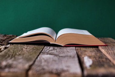 Geri okul kavramı, temiz yeşil tebeşir tahtası, seçici odak, kopya alanı bir fon karşı eski ahşap yüzey üzerinde açık kitap