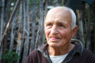 Wattle arka plan karşı çok yaşlı bir adamın yakın çekim portresi, seçici odak