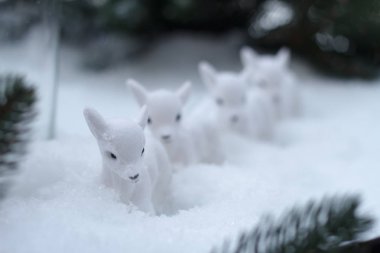 Noel ağacı dalları, seçici odak bir arka plan karşı karda küçük beyaz geyik birkaç heykelleri yakın çekim