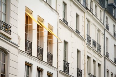 Paris'in merkezinde tarihi bir binanın duvarında kumaş markizli bir pencerenin yakın çekim, seçici odak