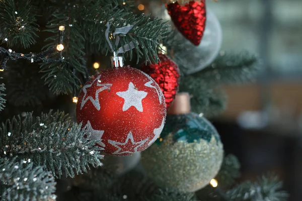 Primer plano bolas de navidad blancas y rojas con una guirnalda dorada en ramas de árbol de navidad, enfoque selectivo — Foto de Stock