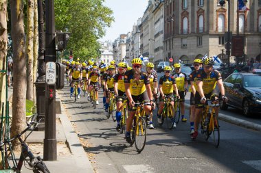 Paris'in merkezinde bisiklete binmek, sarı üniformalı birçok bisikletçi Paris'teki Seine seti boyunca bisiklete biniyor