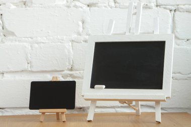 Beyaz tuğla duvar arka plan üzerinde iki minyatür tebeşir tahtası yakın çekim, seçici odak