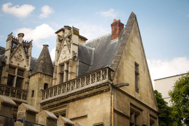 Musee de Cluny'nin çatısındaki fakültelerin mimari detayları ve amblemleri, ortaçağ sanatları ve Ortaçağ'ın tarihi ulusal müzesi