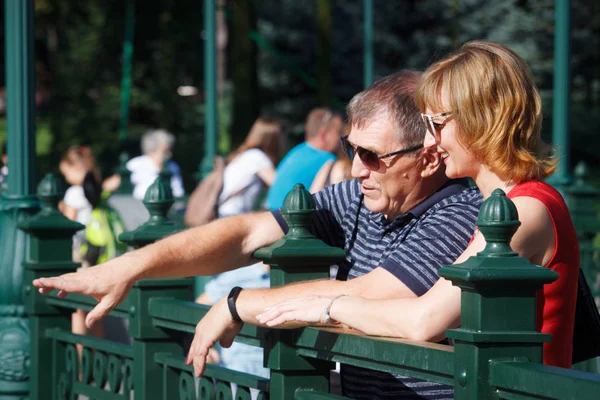 Casal de meia-idade sorrindo e abraçando em um passeio em um parque público, no fundo da fonte, foco seletivo — Fotografia de Stock