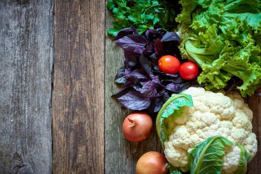 Eski pürüzlü ahşap yüzeyde taze sebze ve otlar, sağlıklı beslenme konsepti, seçici odak