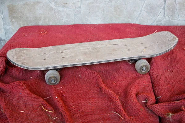 Oude Vintage houten skateboard op een vuil rood oppervlak, selectieve focus — Stockfoto