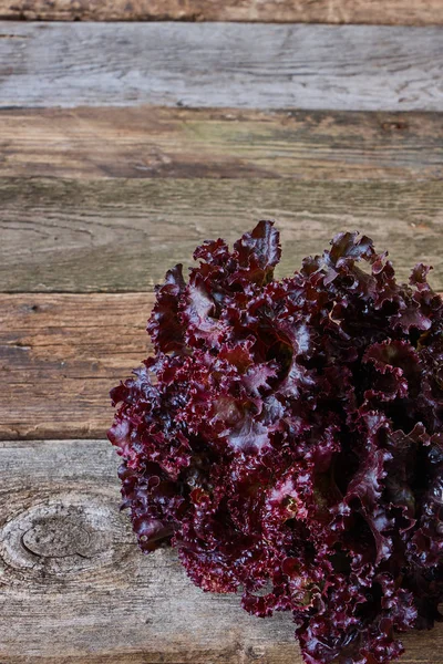 Eski pürüzlü ahşap yüzey, sağlıklı beslenme konsepti, seçici odak üzerinde kırmızı taze salata Başkanı