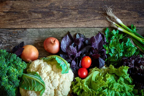 Eski pürüzlü ahşap yüzeyde taze sebze ve otlar, sağlıklı beslenme konsepti, seçici odak