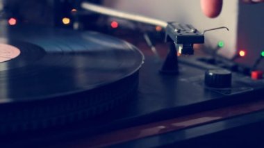 Yakın çekim el bir antika kayıt çalar dönüm ve bir vintage pikap üzerinde iğne çalma kayıt albümü, vinil kayıt iplik, seçici odak