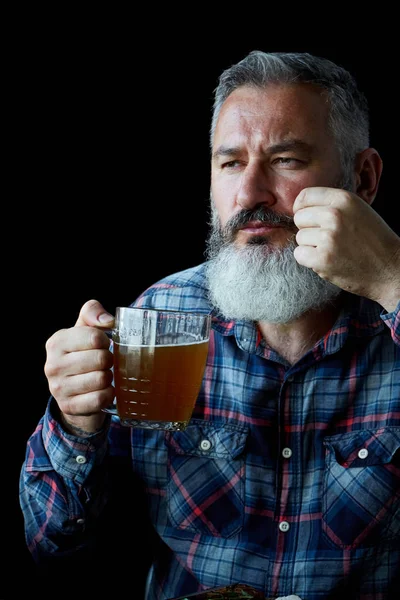 Brutal gray-haired adult man with a beard drinks beer, concept of a holiday, festival, Oktoberfest or St. Patrick's Day — Stock Photo, Image