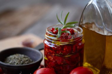 Rustik ahşap yüzeyde Provencal otlar, sarımsak ve zeytinyağı ile güneşte kurutulmuş domates, seçici odak