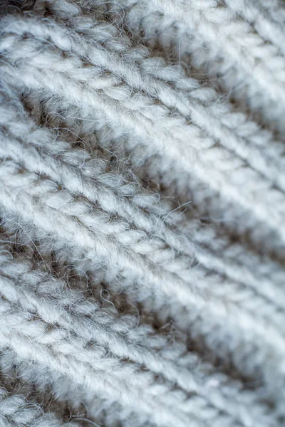 Ακραία κοντινό-up γκρι χρώμα πλεκτό πουλόβερ κατασκευασμένο από φυσικό μαλλί υφή, κυματιστές πτυχώσεις, επιλεκτική εστίαση — Φωτογραφία Αρχείου