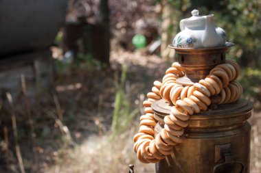 Üzerinde bir çaydanlık ile eski bir bronz ahşap yanan samovar üstüne simit bir demet, seçici odak