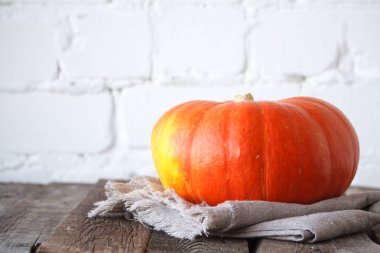 Şükran masasında yakın çekim sonbahar balkabağı, beyaz tuğla zemin, seçici odak