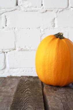 Şükran masasında yakın çekim sonbahar balkabağı, beyaz tuğla zemin, seçici odak