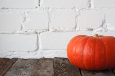 Şükran masasında yakın çekim sonbahar balkabağı, beyaz tuğla zemin, seçici odak