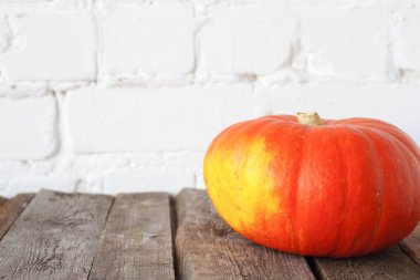 Şükran masasında yakın çekim sonbahar balkabağı, beyaz tuğla zemin, seçici odak