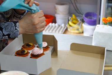 Şekerlemeci bir pastanede kremalı kekler süsler