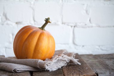 Şükran masasında yakın çekim sonbahar balkabağı, beyaz tuğla zemin, seçici odak