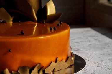 Karamel krema kek hafif bir yüzey, seçici odak altın folyo ve çikolata damla ile süslenmiş