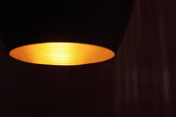 Close-up of yellow light from a lamp shade in a dark room of a room, selective focus — Stock Photo, Image