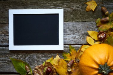 Şükran Günü sonbahar arkaplanı koyu ahşap bir zemin, kabaklar, kurumuş yapraklar, meşe palamutları, kestaneler ve yazıtlar için bir çerçeve, seçici odaklanma.