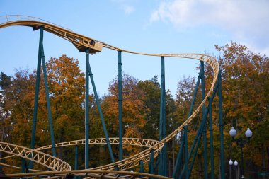 Modern lunaparka, mavi gökyüzüne ve beyaz bulutlara karşı hız trenine binmek, eğlence festivali.