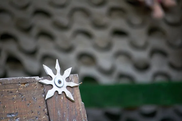 Close-up throwing board for throwing star decorated with broken shurikens, selective focus — Stock Photo, Image