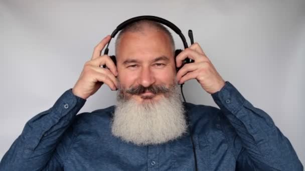 Call center emplovers put headset on head, matre caucasian bearded man put on his headphone, looks happy and thumbs up, grey background. — Stok Video