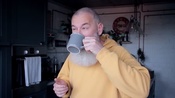 快乐的大胡子男人早上在家里喝咖啡，在厨房里跳舞，早上好概念，模糊的背景 — 图库视频影像