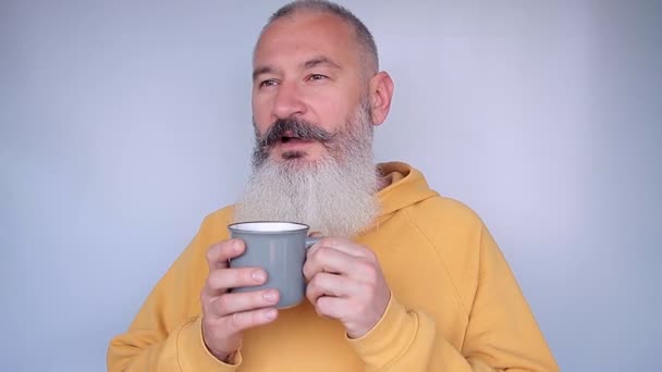 Feliz hombre maduro bebiendo bebida taza. Buenos días concepto. Fondo gris . — Vídeo de stock