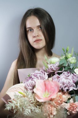 Güzel bir buketi olan uzun saçlı esmer kız portresi, hediye ya da tebrik konsepti, evlilik teklifi ya da nişan. Şefkat, güzellik ve romantizm kavramı.