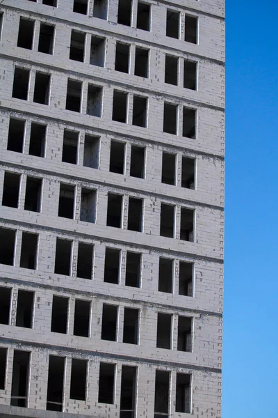 Новий багатоповерховий готовий до введення в експлуатацію будівлі з білої цегли на блакитне небо, вільний простір для тексту — стокове фото