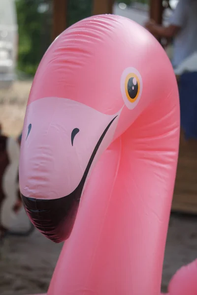 Juguete inflable gigante del flotador del flamenco rosado en la playa arenosa del río, concepto de vacaciones de verano — Foto de Stock