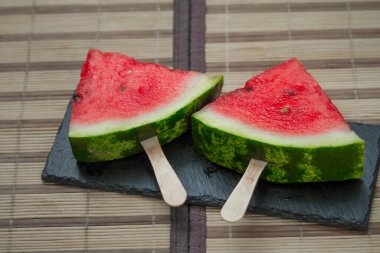 Karpuz dilimi siyah taş kalas üzerinde, dondurma konsepti, seçici odaklanma