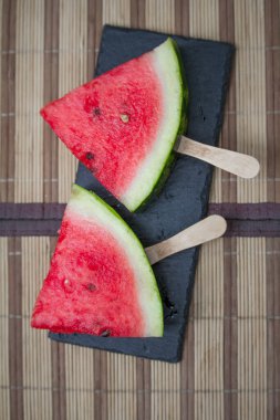 Karpuz dilimi siyah taş kalas üzerinde, dondurma konsepti, seçici odaklanma