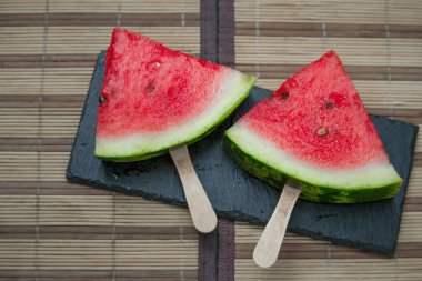 Karpuz dilimi siyah taş kalas üzerinde, dondurma konsepti, seçici odaklanma